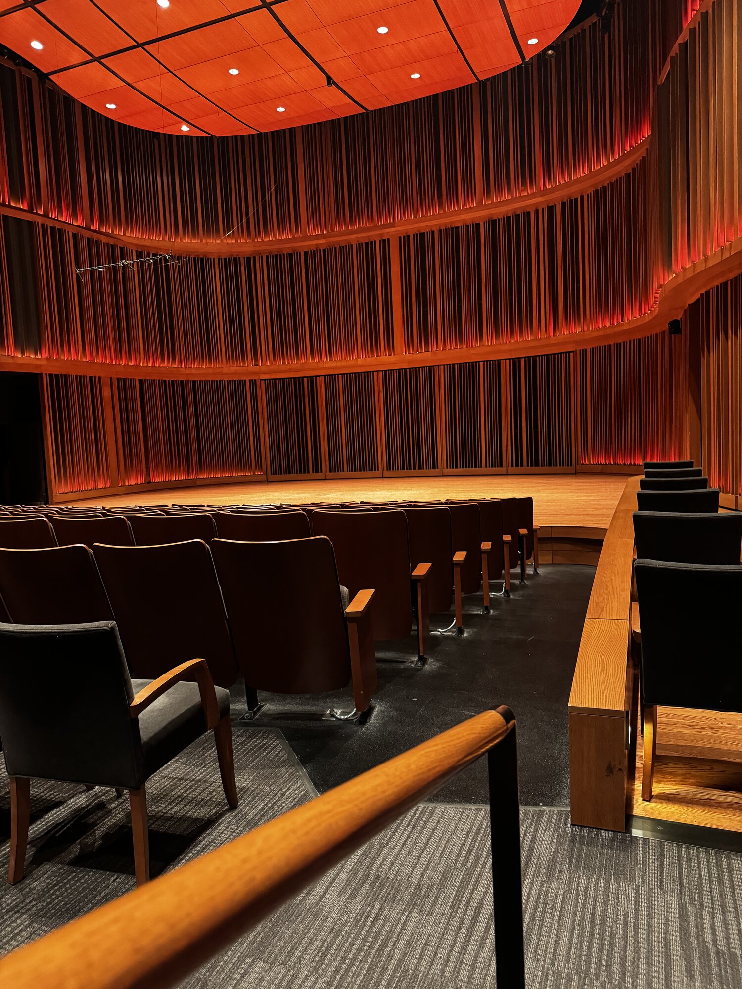 Macalester's curved wood-paneled recital hall, warmly lit