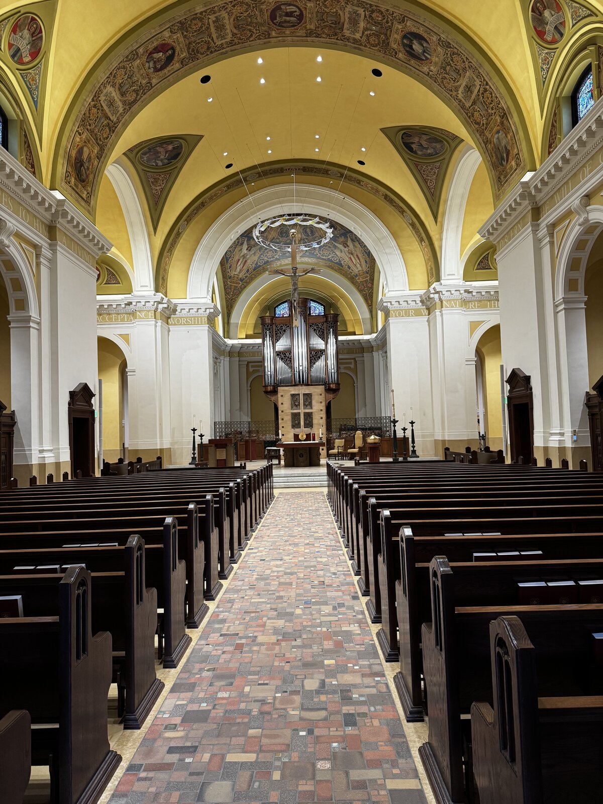 The vaulted nave of the Chapel of St. Thomas Aquinas, with painted ceilings and a mosaic aisle