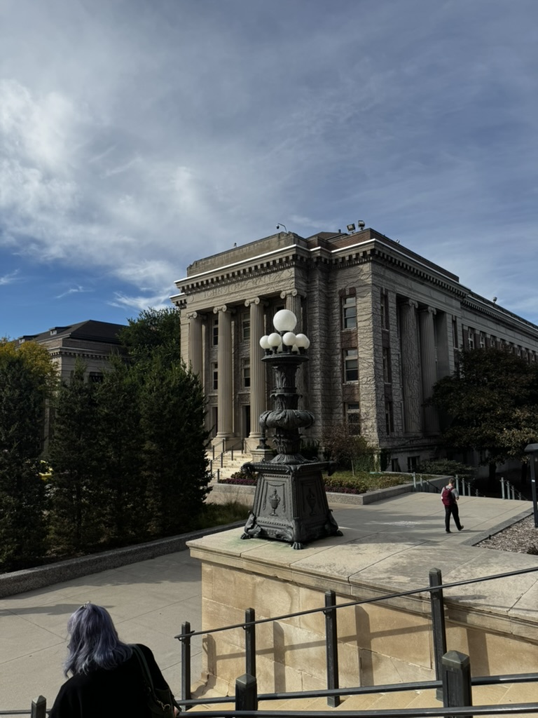 A columned stone building and ornate lamppost on the University of Minnesota mall
